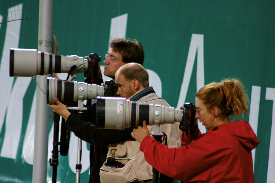 Zwei Fotografen und eine Fotografin mit jeweils einer Kamera und großen Obektiven fotografieren.