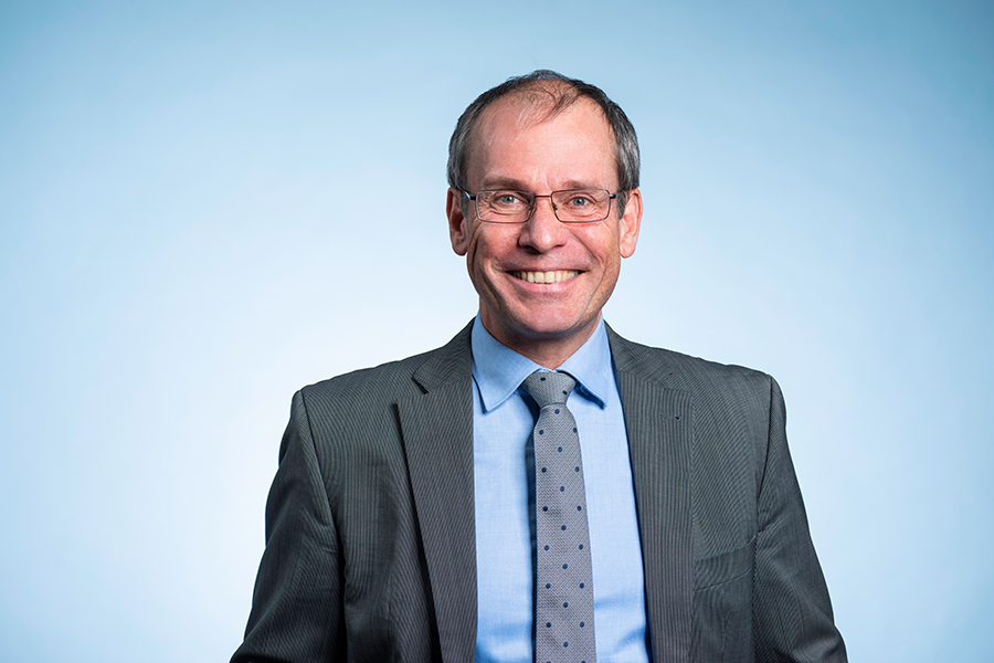 Porträt von IAB-Direktor Professor Bernd Fitzenberger vor hellblauem Hintergrund