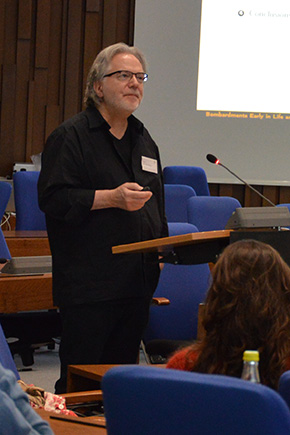 Professor Gerard van den Berg giving his presentation in front of the audience.