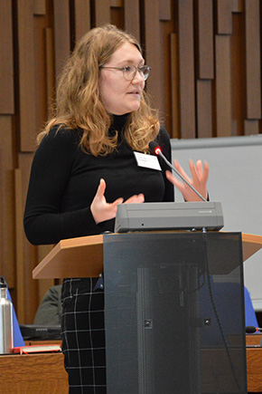 Li Kathrin Kaja Rupieper standing in conference room talking to the audience.