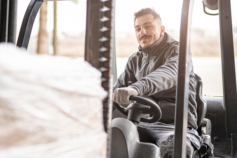 Lächelnder Gabelstaplerfahrer bei der Arbeit