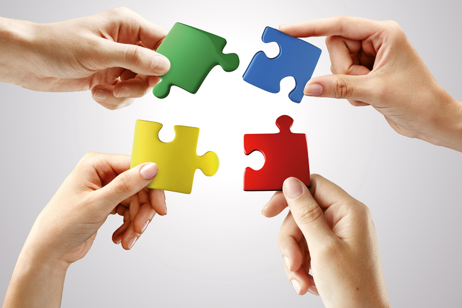 Hands and puzzle on gray background.