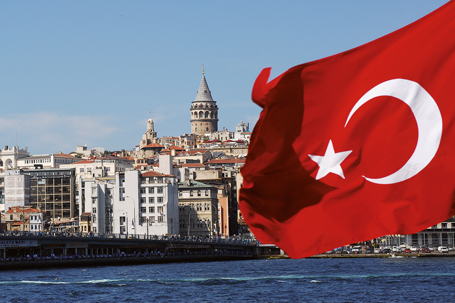 Turkish flag in front of a town by the sea