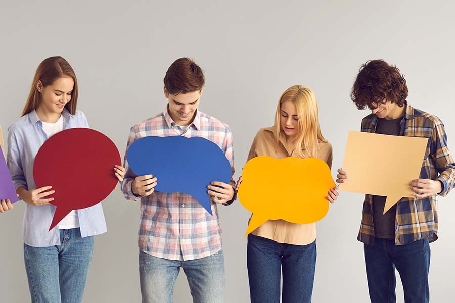 Each of the five young adults is holding a speech bubble, each in a different color.