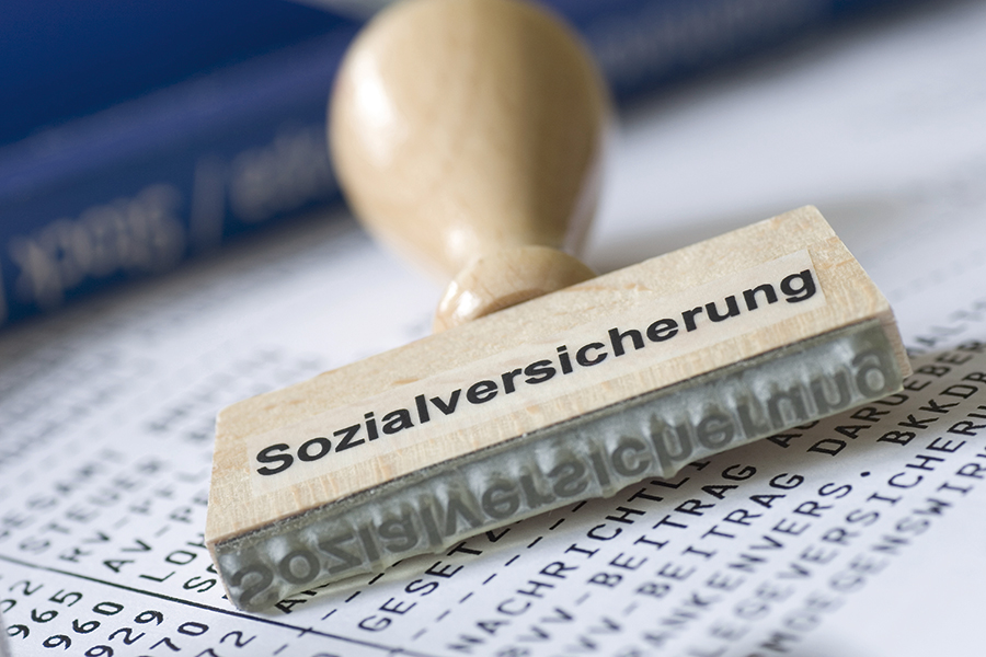 The photo shows a stamp with the inscription "Sozialversicherung".