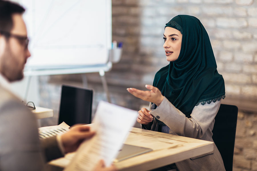 Junge muslimische Frau mit Kopfschleier beim Bewerbungsgespräch
