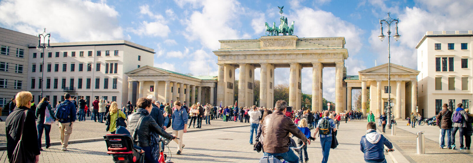 Pedestrians and cyclists in front of the Brandenburg Gate.