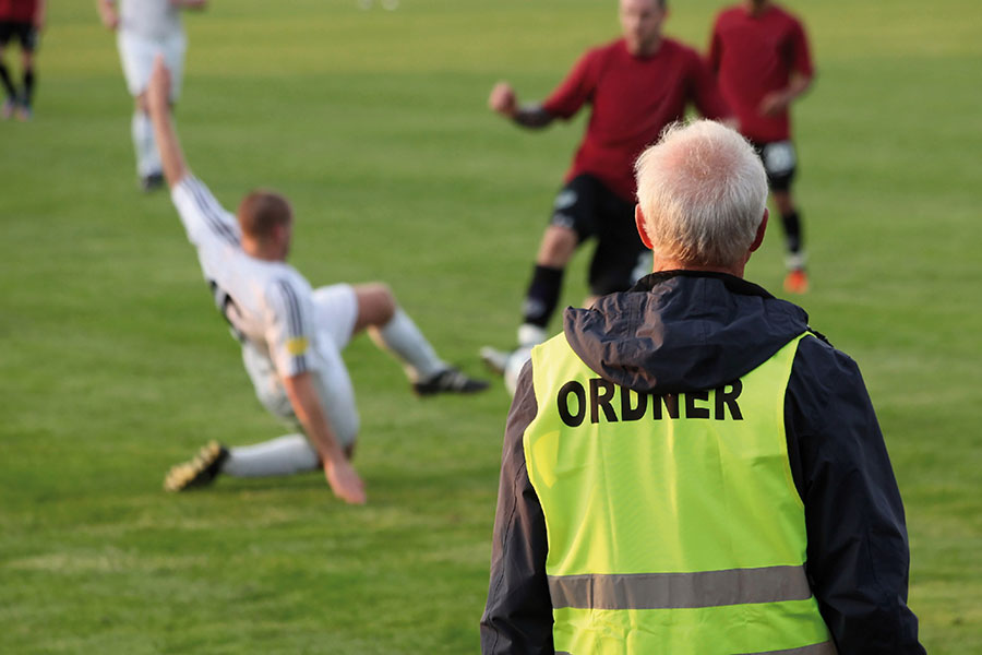 Ordner am Rand eines Fußballspiels.