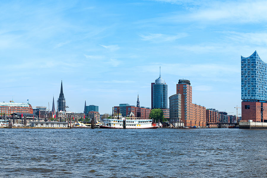 Blick von der Elbe auf die Skyline von Hamburg mit Hafen und Elbphilharmonie.