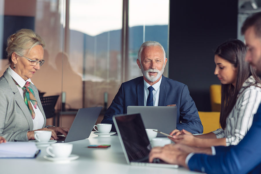 Business-Meeting mit älteren und jüngeren Personen.