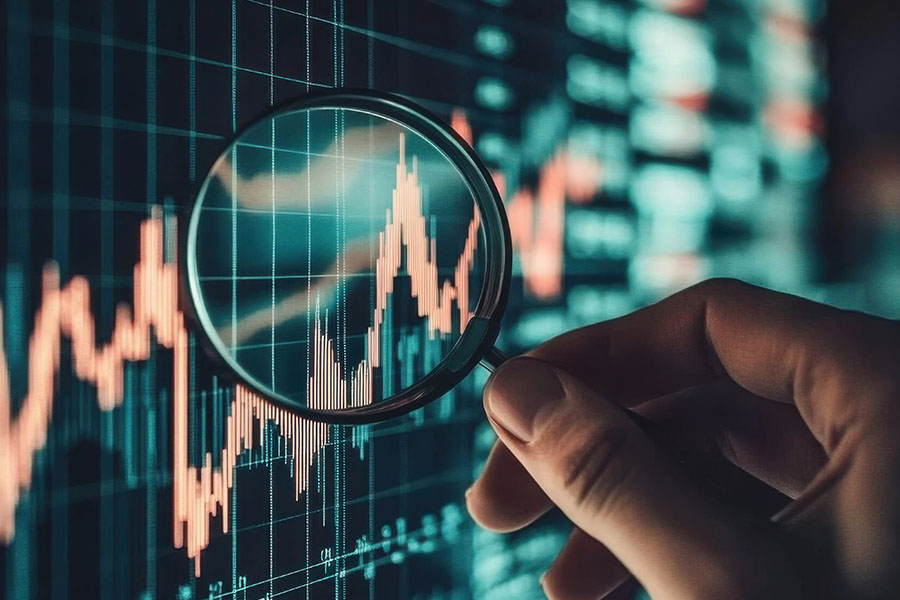 Hand, die eine Lupe auf ein Diagramm auf einem Bildschirm hält.