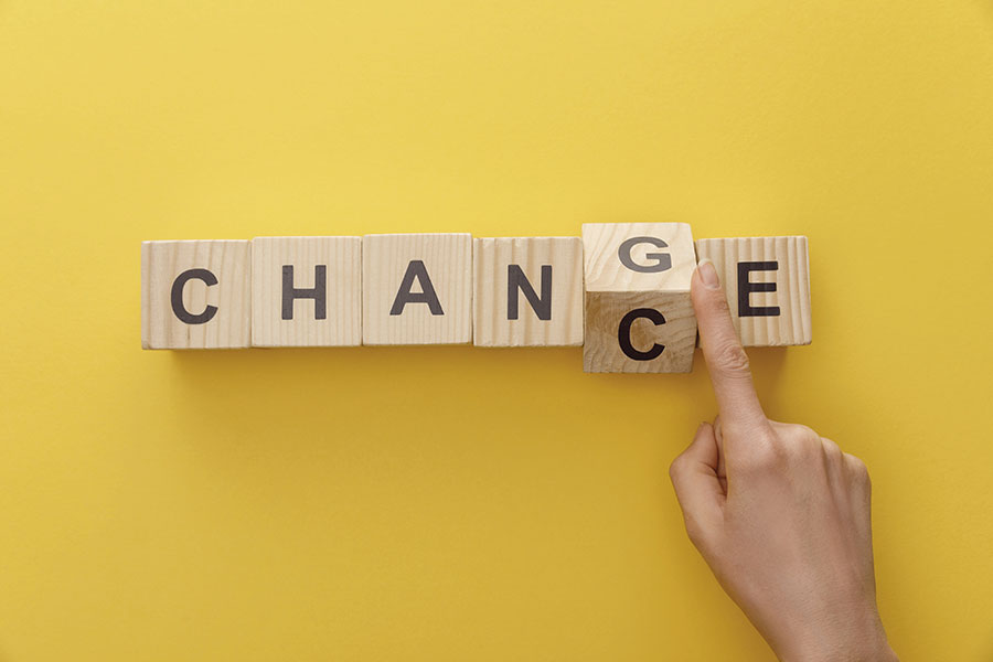 Sechs Holzwürfeln mit je einem Buchstaben darauf liegen so auf einem Tisch, dass sie das Wort „Change“ ergeben. Eine Hand kippt den Würfel mit dem „G“, so dass auf dessen anderer Seite der Buchstabe „C“ und somit das Wort „Chance“ erscheint.